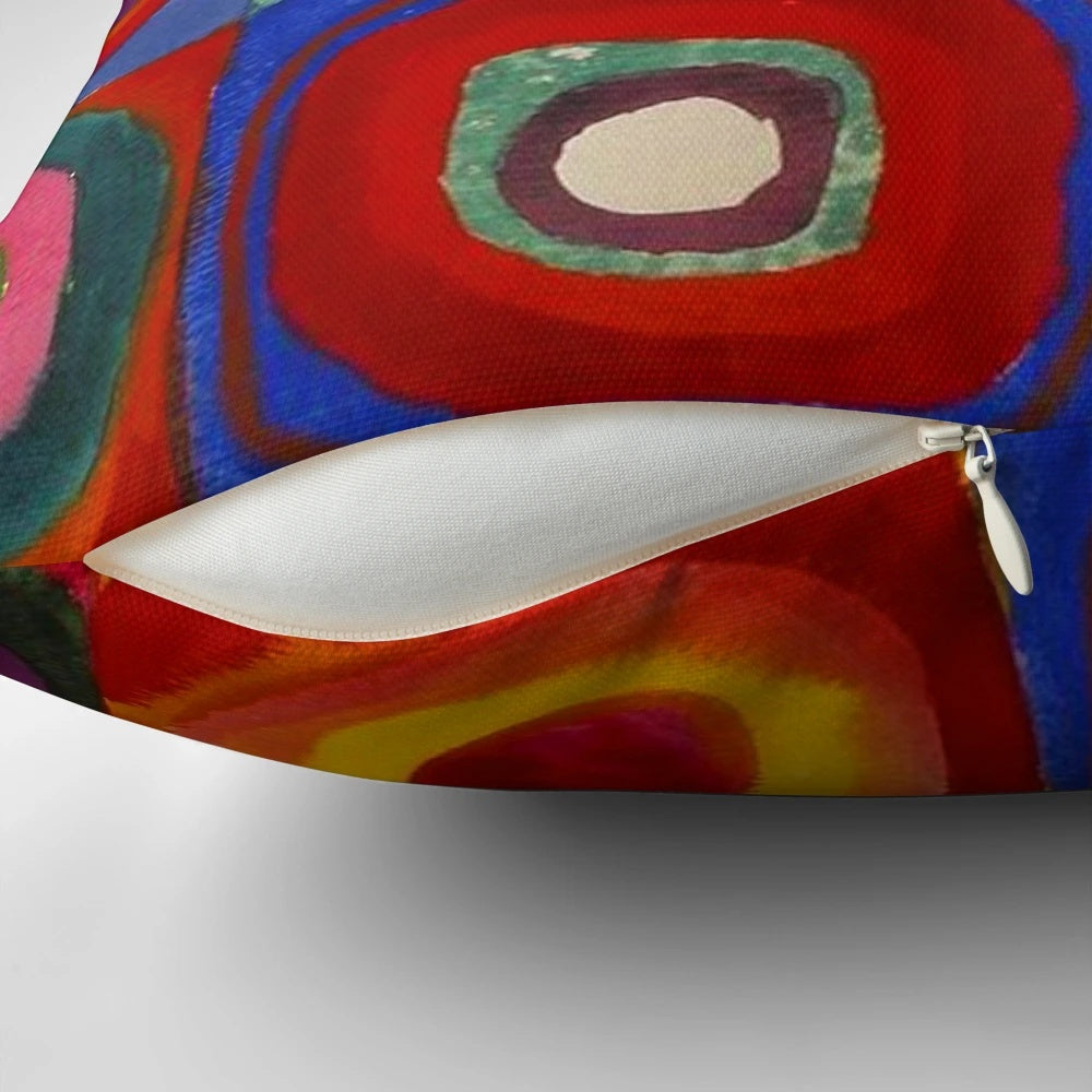 Colorful abstract pillow featuring a design of concentric squares and circles in a variety of bright hues, inspired by the artwork of Wassily Kandinsky.