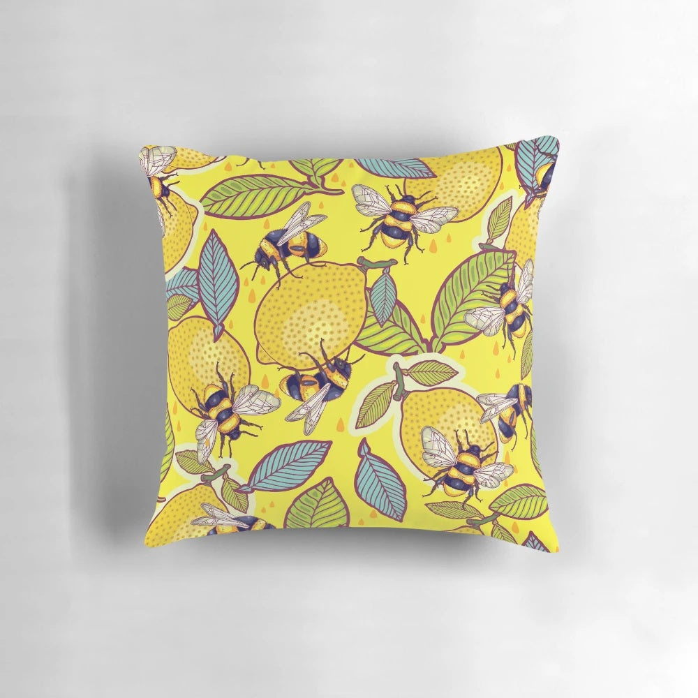 Colorful pillow with a design featuring a lemon, bees, and a garden scene