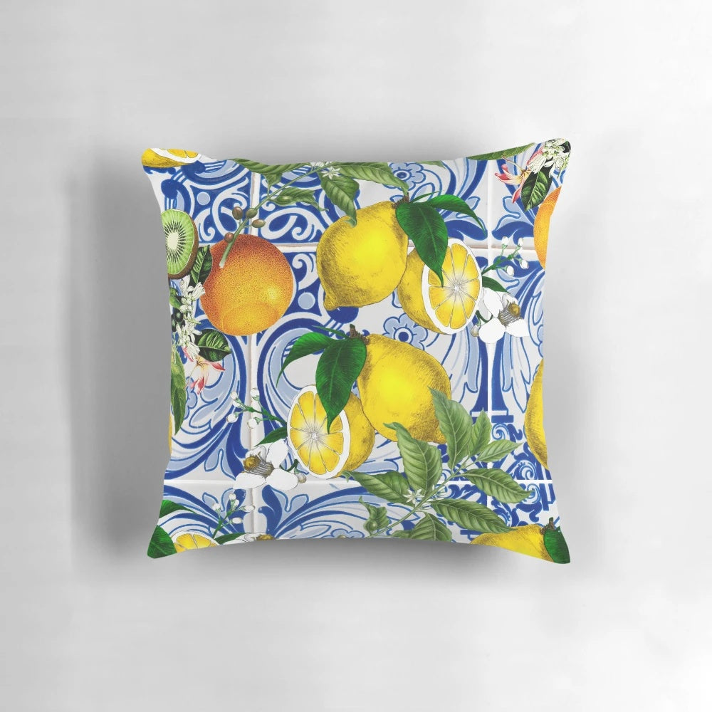 Colorful Mediterranean-inspired pillow with a lemon pattern print against a blue background.