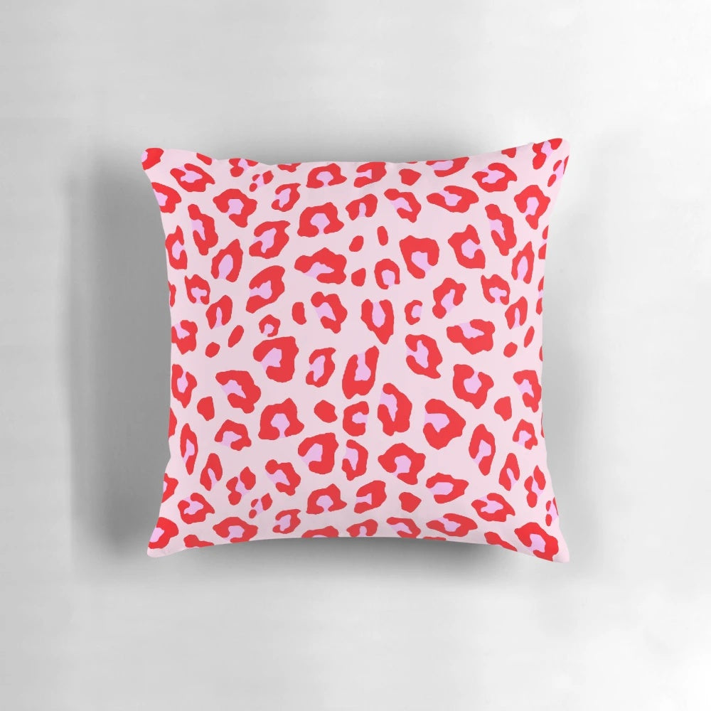 Closeup of a vibrant leopard print pillow in shades of red and pink.