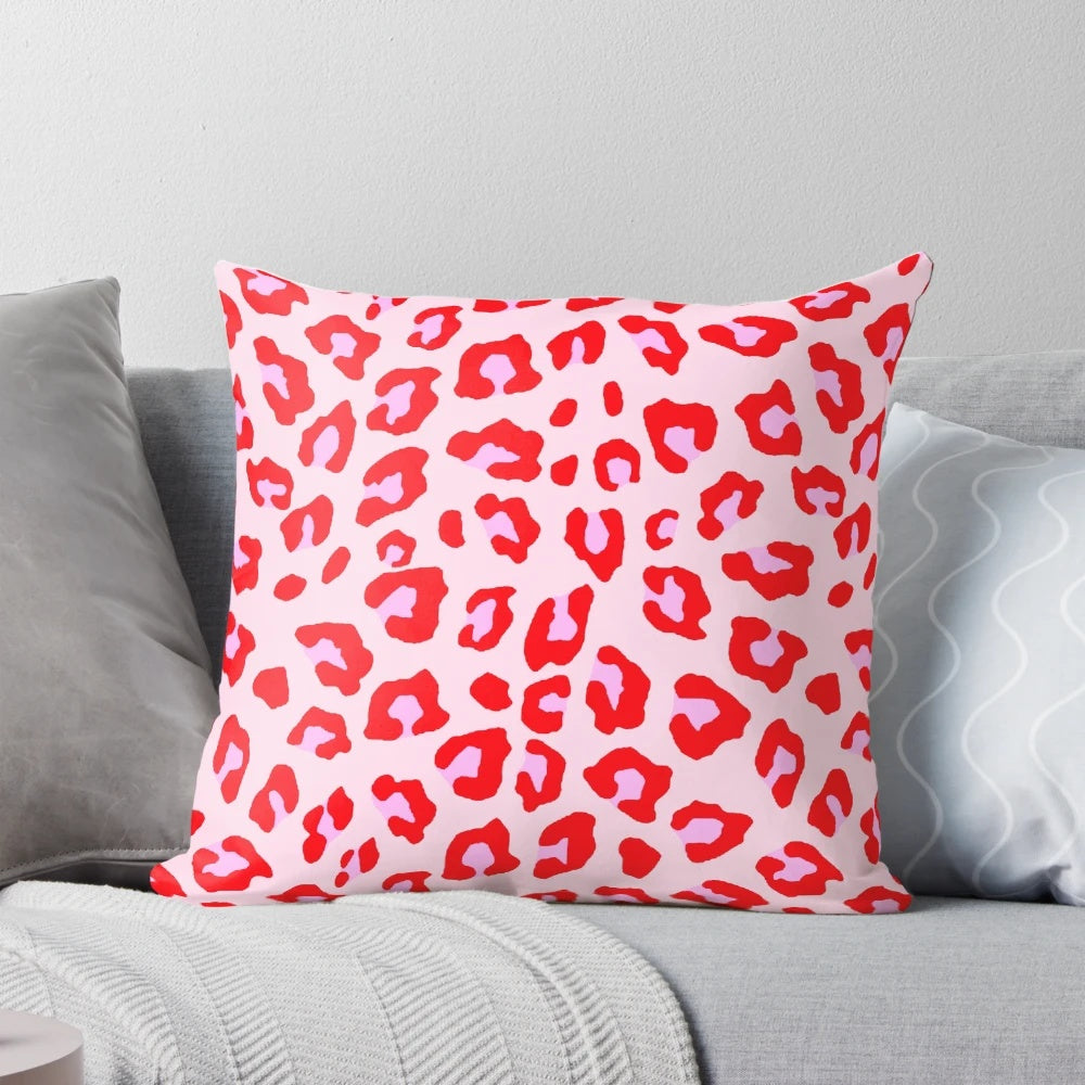 Closeup of a vibrant leopard print pillow in shades of red and pink.