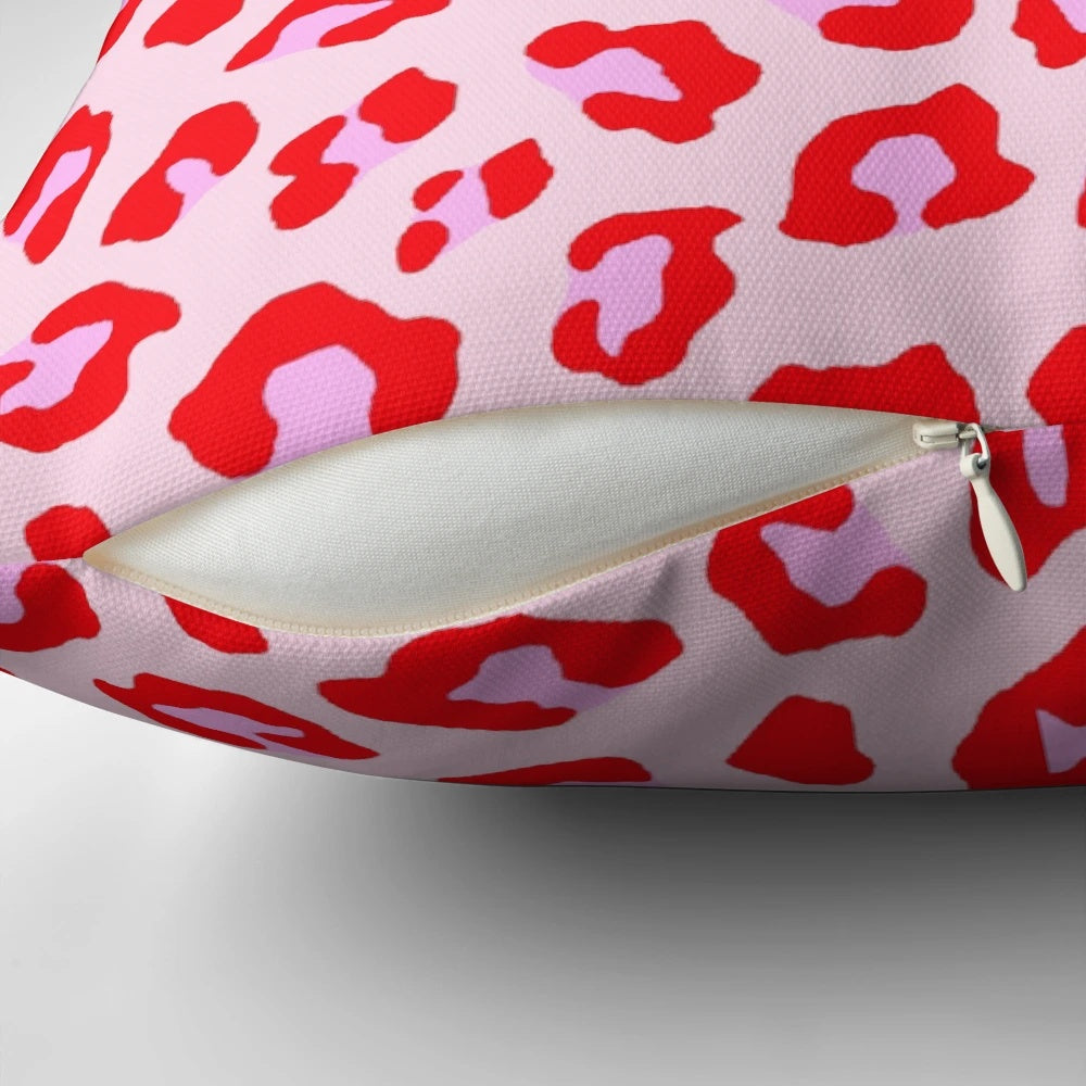 Closeup of a vibrant leopard print pillow in shades of red and pink.