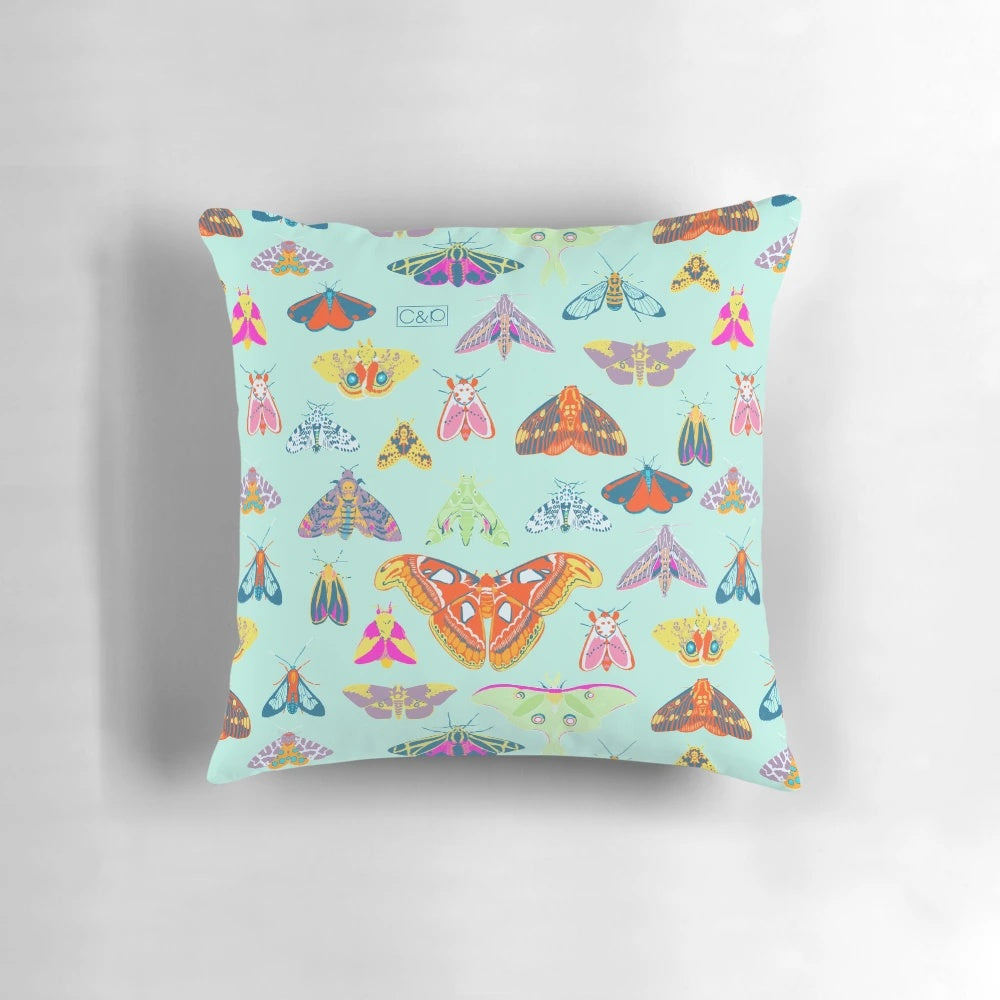 Colorful pillow featuring a variety of moths and butterflies in a nature-inspired surface design.
