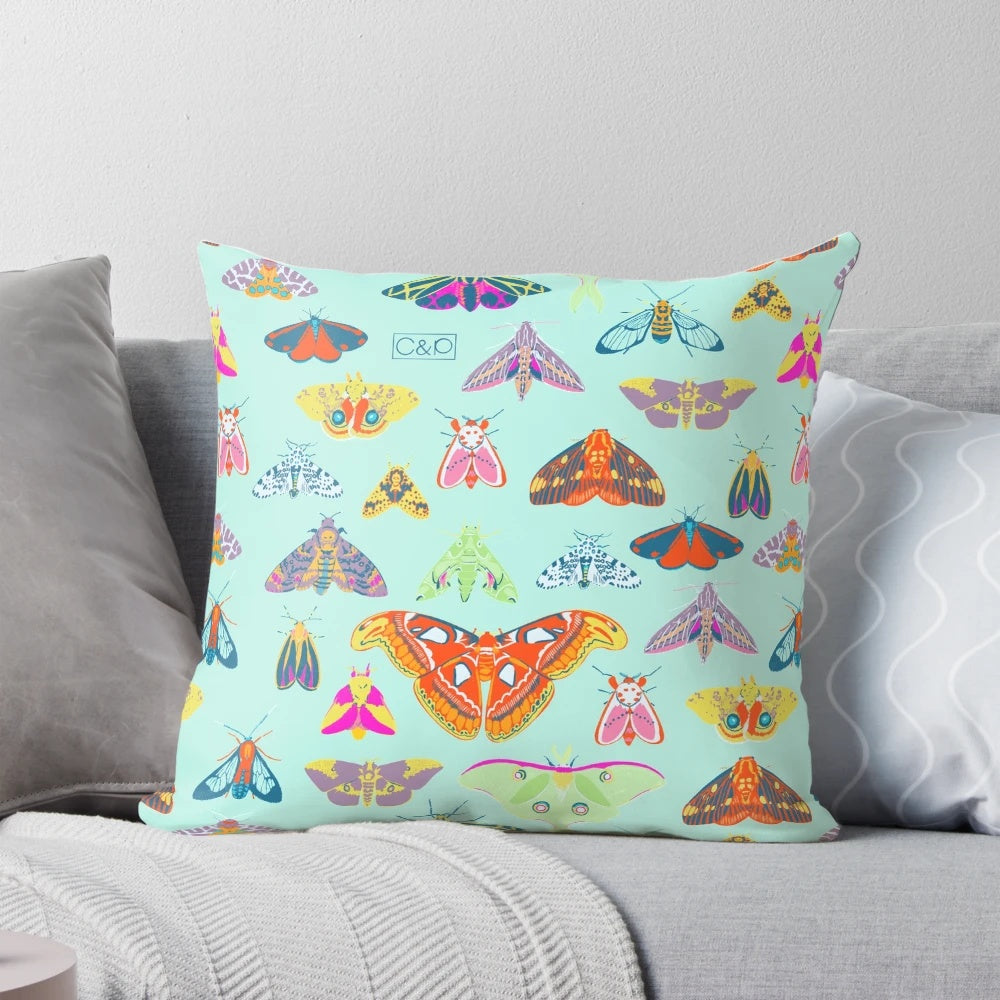 Colorful pillow featuring a variety of moths and butterflies in a nature-inspired surface design.