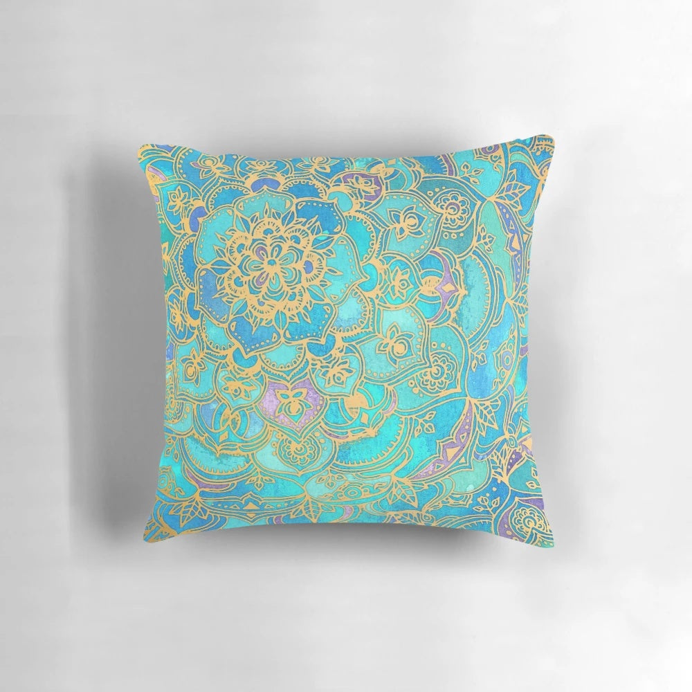 A decorative pillow with a mandala design in teal, turquoise, gold, and yellow hues, inspired by stained glass and bohemian styles.