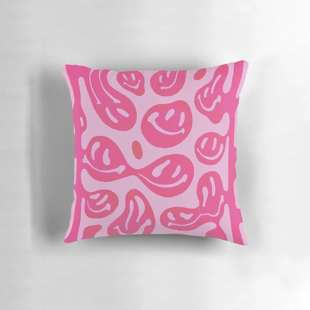 Colorful melted smiley face design on a pink pillow, with a psychedelic, vibrant pattern.
