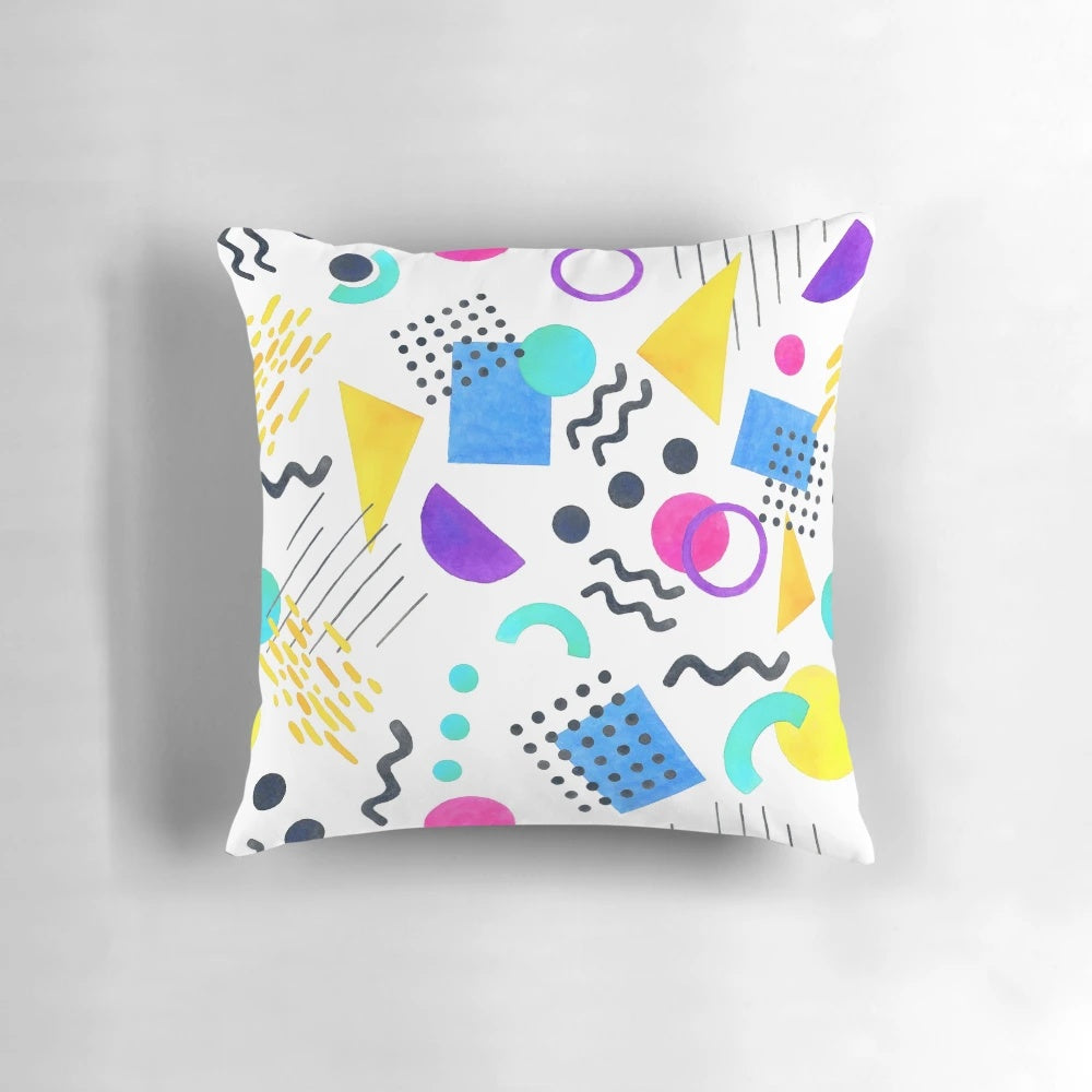 Colorful Memphis-inspired decorative pillow with geometric patterns and watercolor-like design.