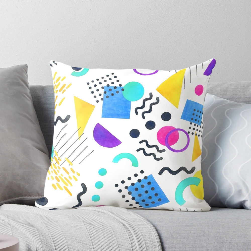 Colorful Memphis-inspired decorative pillow with geometric patterns and watercolor-like design.
