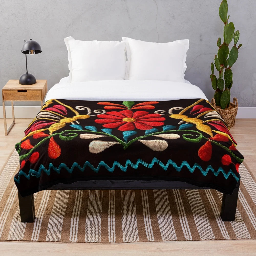 Colorful plush blanket featuring a design of butterflies and a red flower, representing Mexican art and design