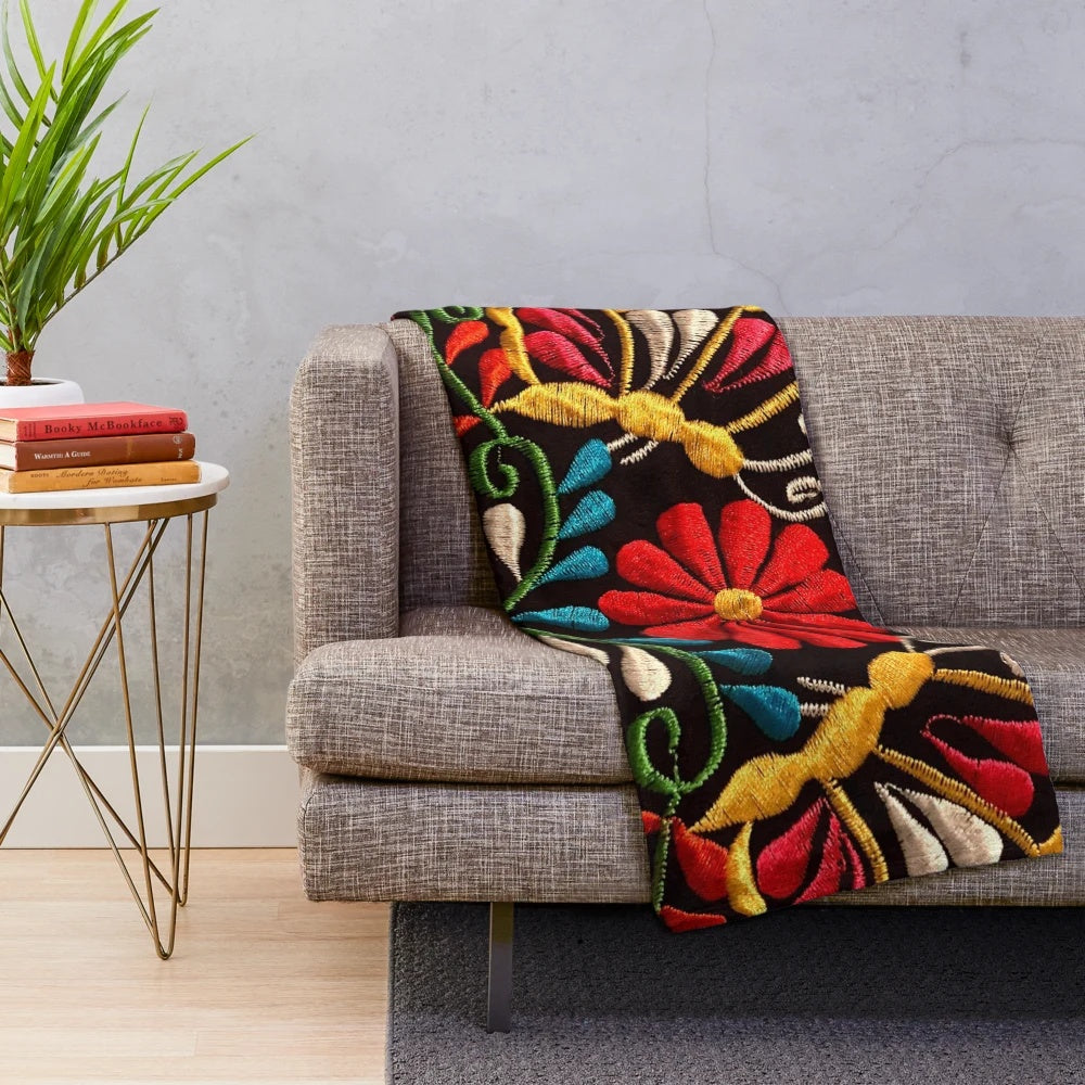 Colorful plush blanket featuring a design of butterflies and a red flower, representing Mexican art and design
