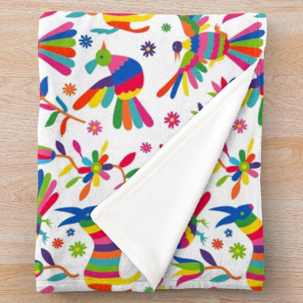 Colorful Mexican Otomi inspired plush blanket featuring vibrant patterns of birds, flowers, and animals