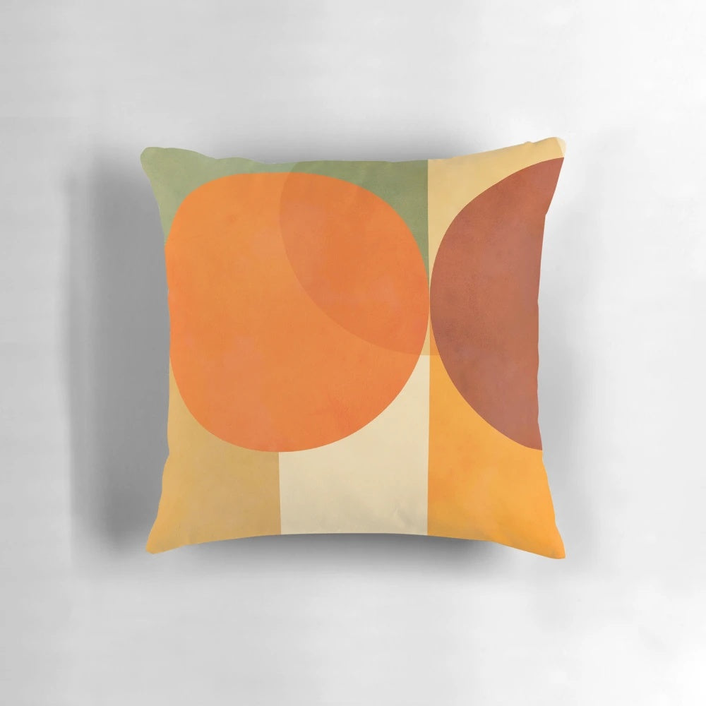 A colorful abstract geometric throw pillow in shades of green and orange, featuring a mid-century modern design.
