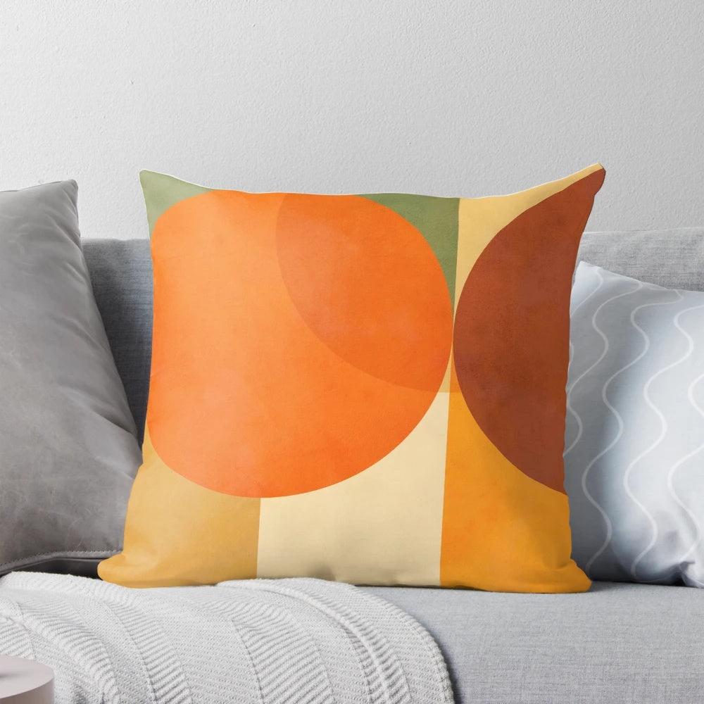A colorful abstract geometric throw pillow in shades of green and orange, featuring a mid-century modern design.