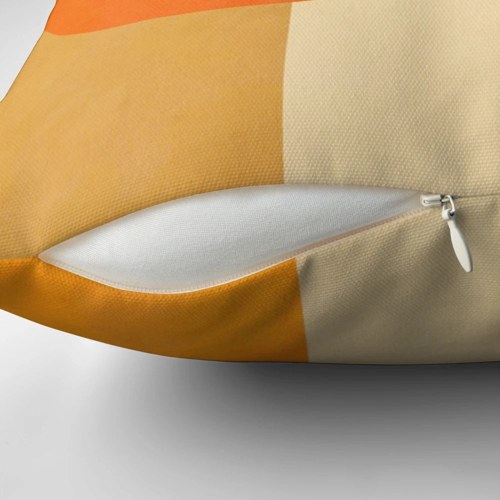 A colorful abstract geometric throw pillow in shades of green and orange, featuring a mid-century modern design.