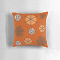 An orange pillow featuring a vibrant mid century modern starburst pattern, reflecting the 20th century space age aesthetic.