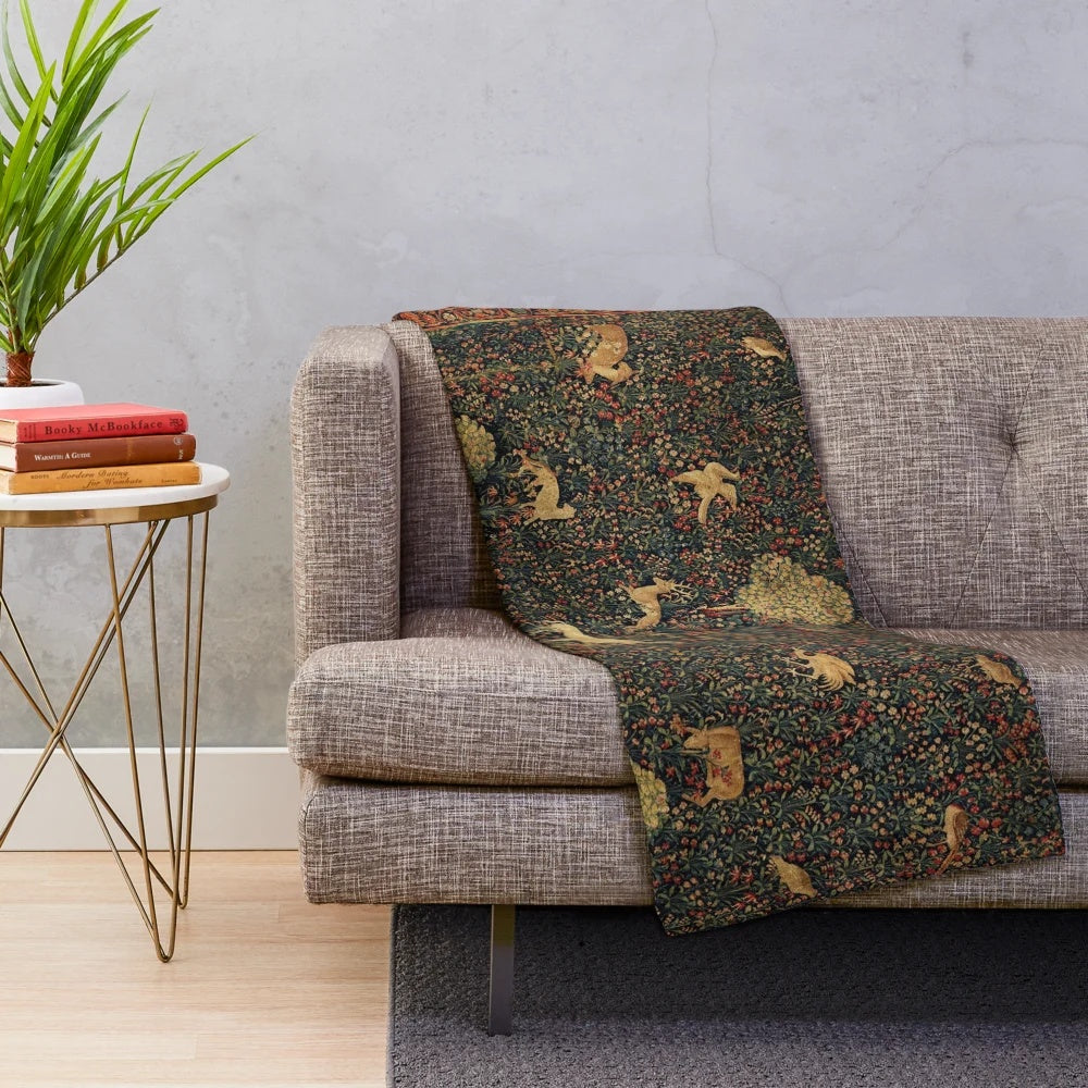 Millefleurs tapestry plush blanket featuring a fantasy medieval scene with a unicorn, deer, and other mythical creatures