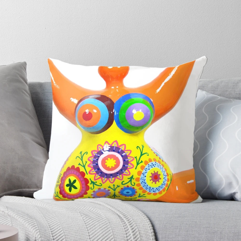 Vibrant orange pillow featuring a Nana-style design, a tribute to the iconic sculptures of Niki de Saint Phalle