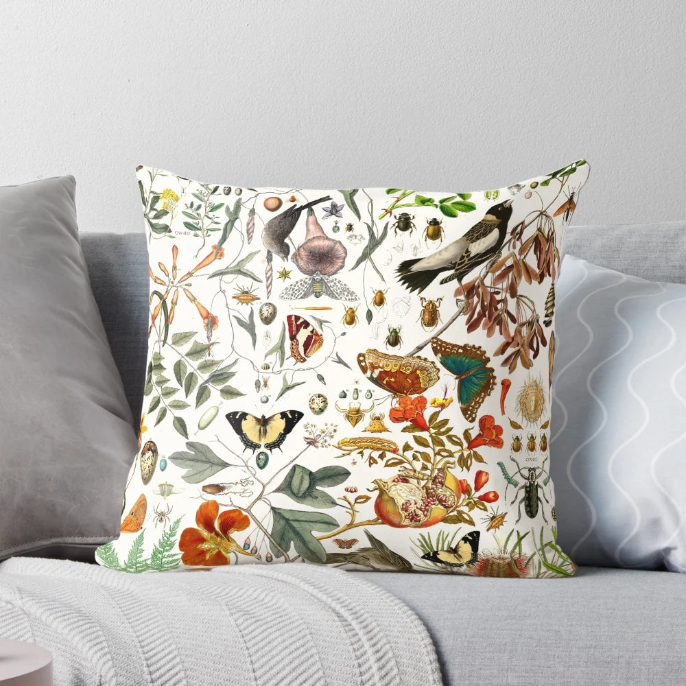 Closeup of a vibrant nature-inspired throw pillow featuring detailed illustrations of butterflies, birds, and flowers.