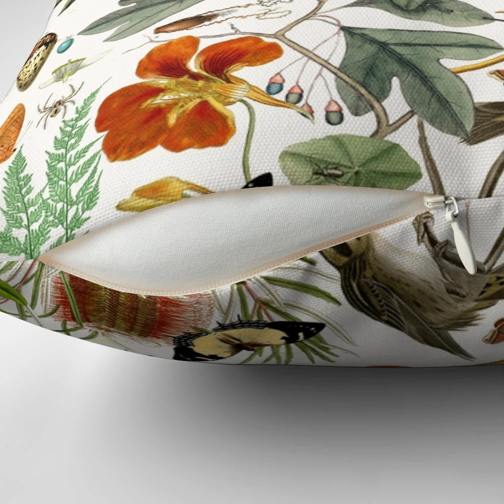 Closeup of a vibrant nature-inspired throw pillow featuring detailed illustrations of butterflies, birds, and flowers.