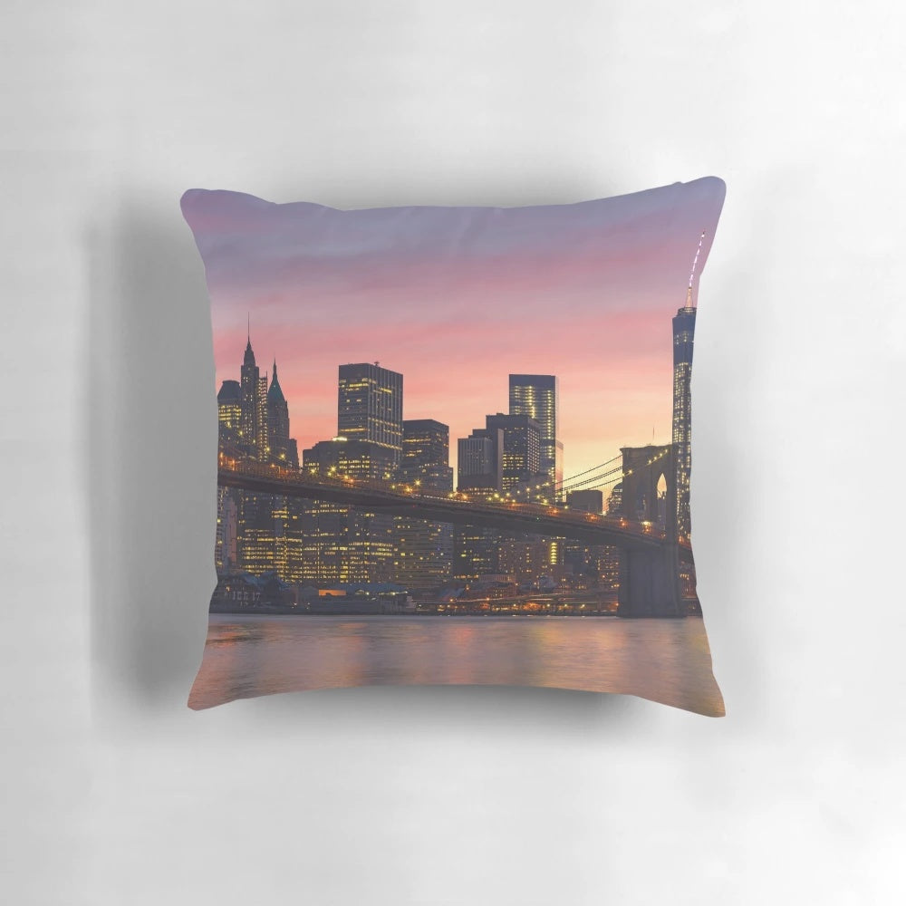 Decorative throw pillow featuring a stunning New York City skyline design with the Brooklyn Bridge, skyscrapers, and a vibrant sunset.
