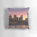 Decorative throw pillow featuring a stunning New York City skyline design with the Brooklyn Bridge, skyscrapers, and a vibrant sunset.