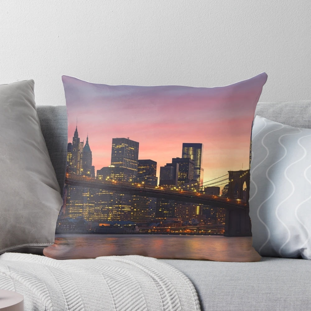 Decorative throw pillow featuring a stunning New York City skyline design with the Brooklyn Bridge, skyscrapers, and a vibrant sunset.