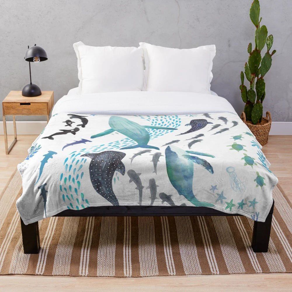 Colorful plush blanket featuring watercolor designs of ocean animals including whales, sharks, and sea turtles