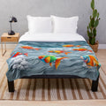 Colorful ocean life plush blanket with dolphin, whale, and seashell motifs
