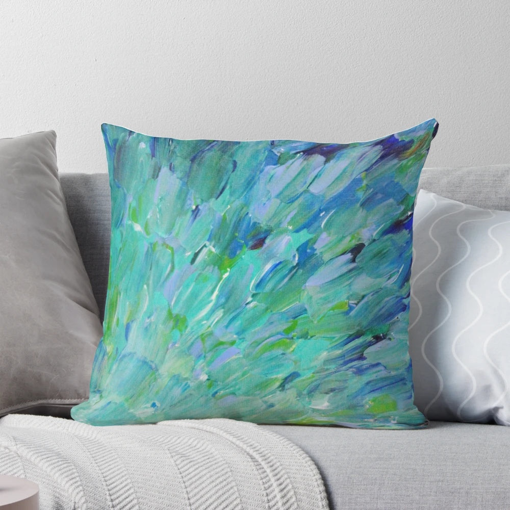 Decorative pillow featuring an abstract design with peacock feathers, mermaid fins, and ocean waves in shades of teal, navy, and avocado green.