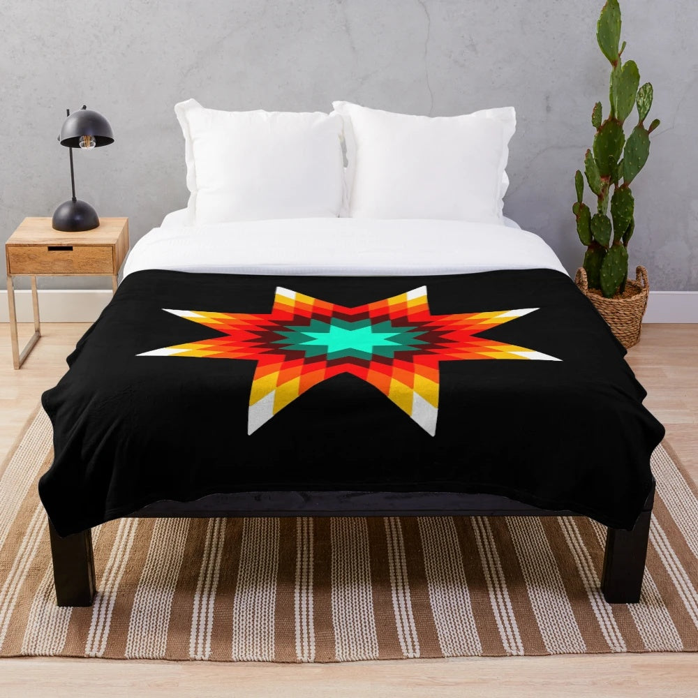 Plush blanket with a vibrant star quilt pattern in fire colors inspired by Ojibwe floral designs