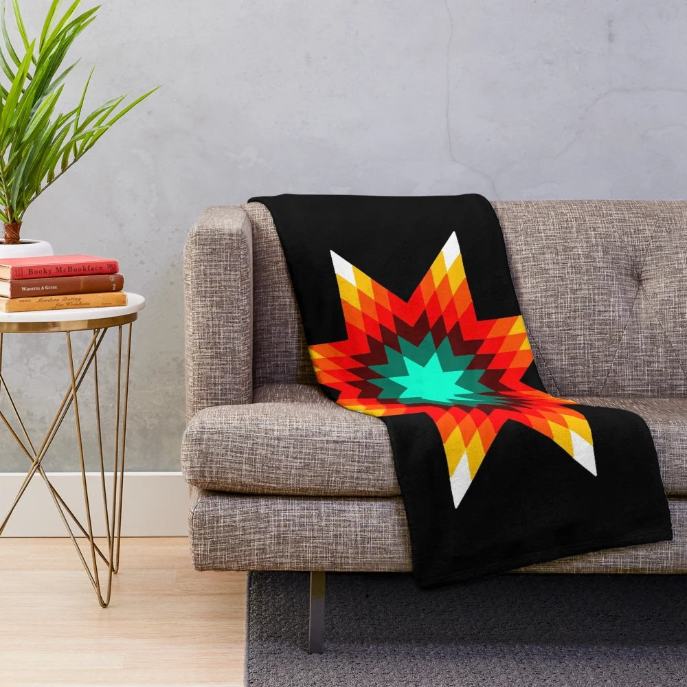 Plush blanket with a vibrant star quilt pattern in fire colors inspired by Ojibwe floral designs