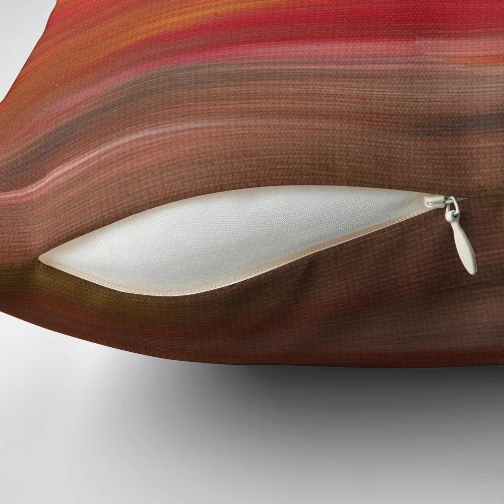 Colorful abstract ombre painting in shades of red, yellow, and black on a decorative throw pillow.