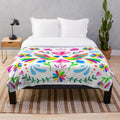 Otomi-inspired plush blanket with colorful floral and animal patterns