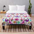 Colorful Otomi-inspired plush blanket featuring traditional Mexican patterns and designs