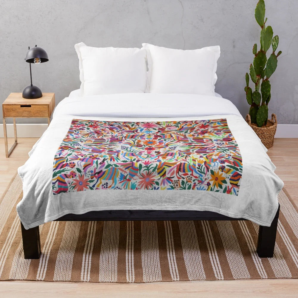 Colorful Otomi-inspired plush blanket with traditional Mexican art patterns
