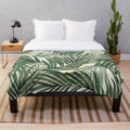 Soft, plush blanket featuring a watercolor palm leaves design in a lush, green color palette