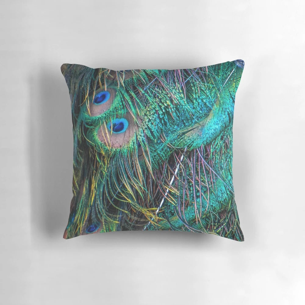 Vibrant and luminous peacock feather pillow with shimmering green, purple, and blue hues