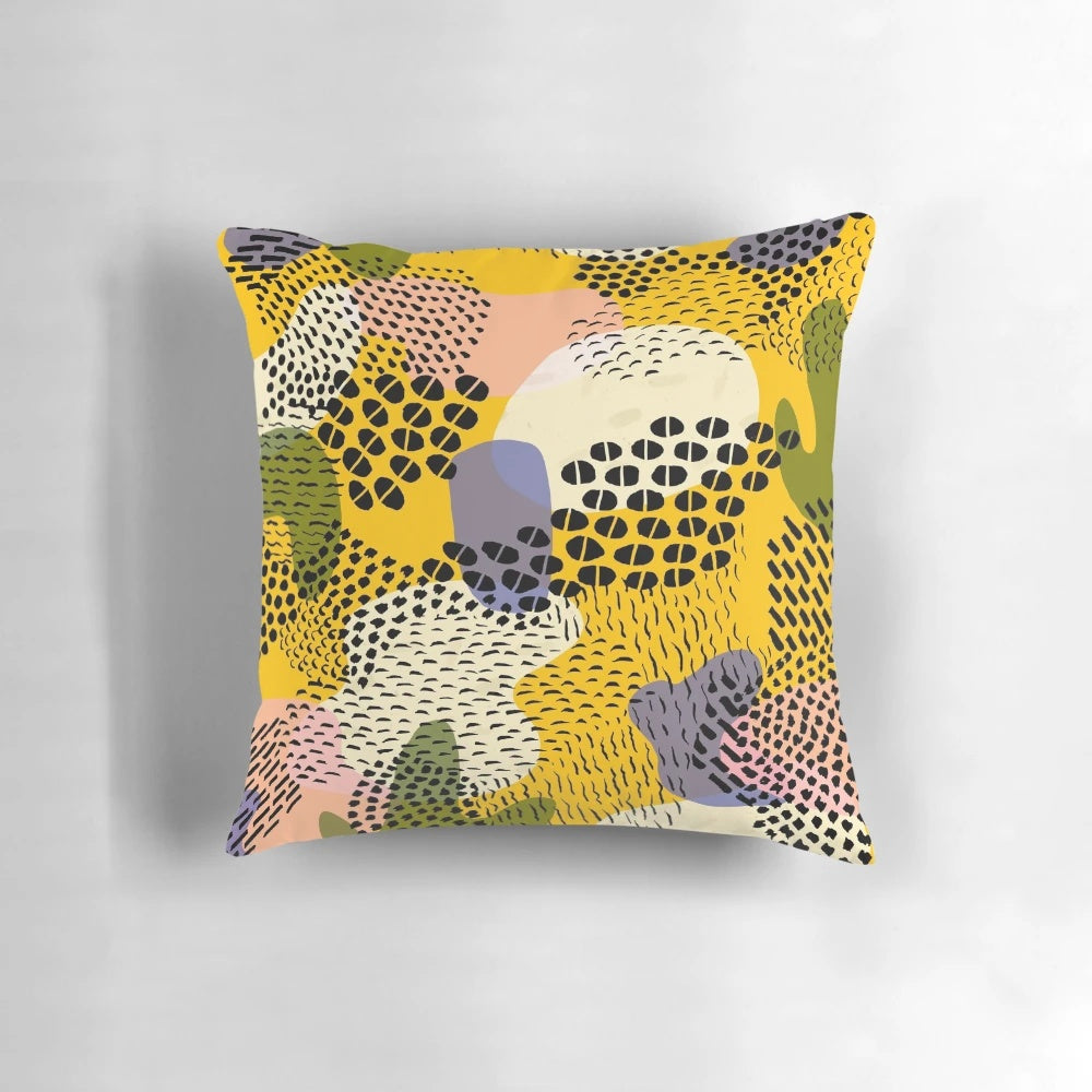 Colorful pina colada-inspired pillow with abstract geometric patterns of dots, circles, and lines in yellow, green, and purple