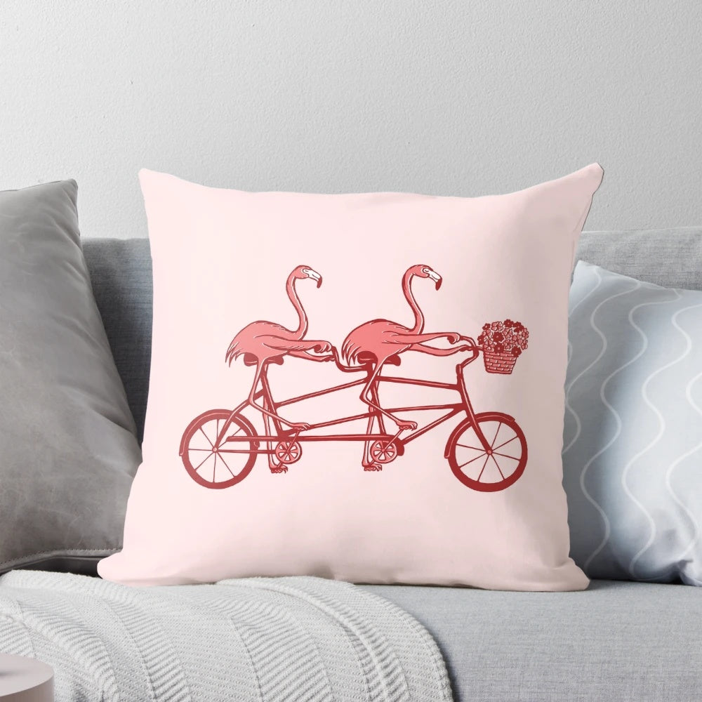 Colorful pink flamingos riding a tandem bicycle on a decorative pillow