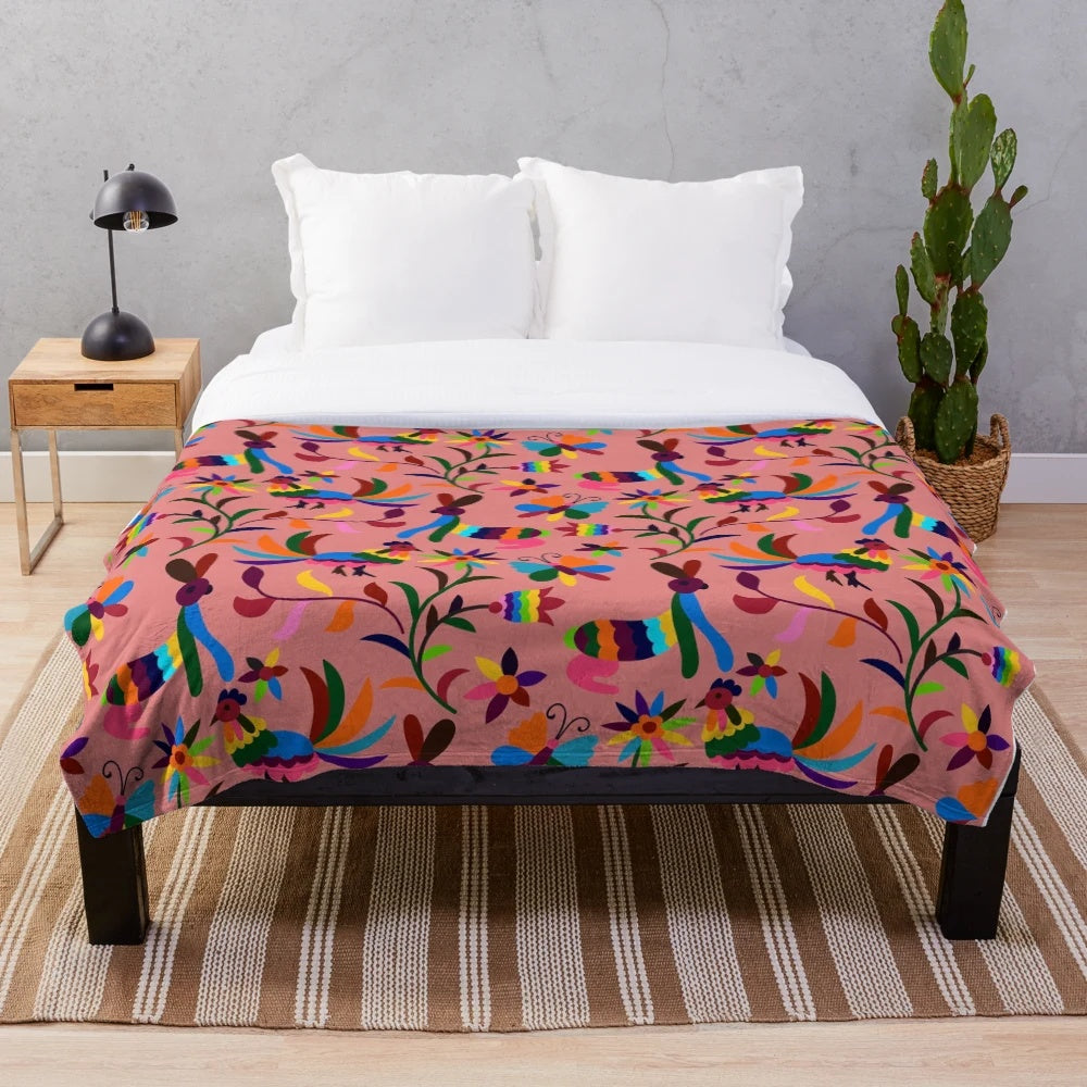 Pink plush blanket with colorful otomi pattern featuring cartoon animals