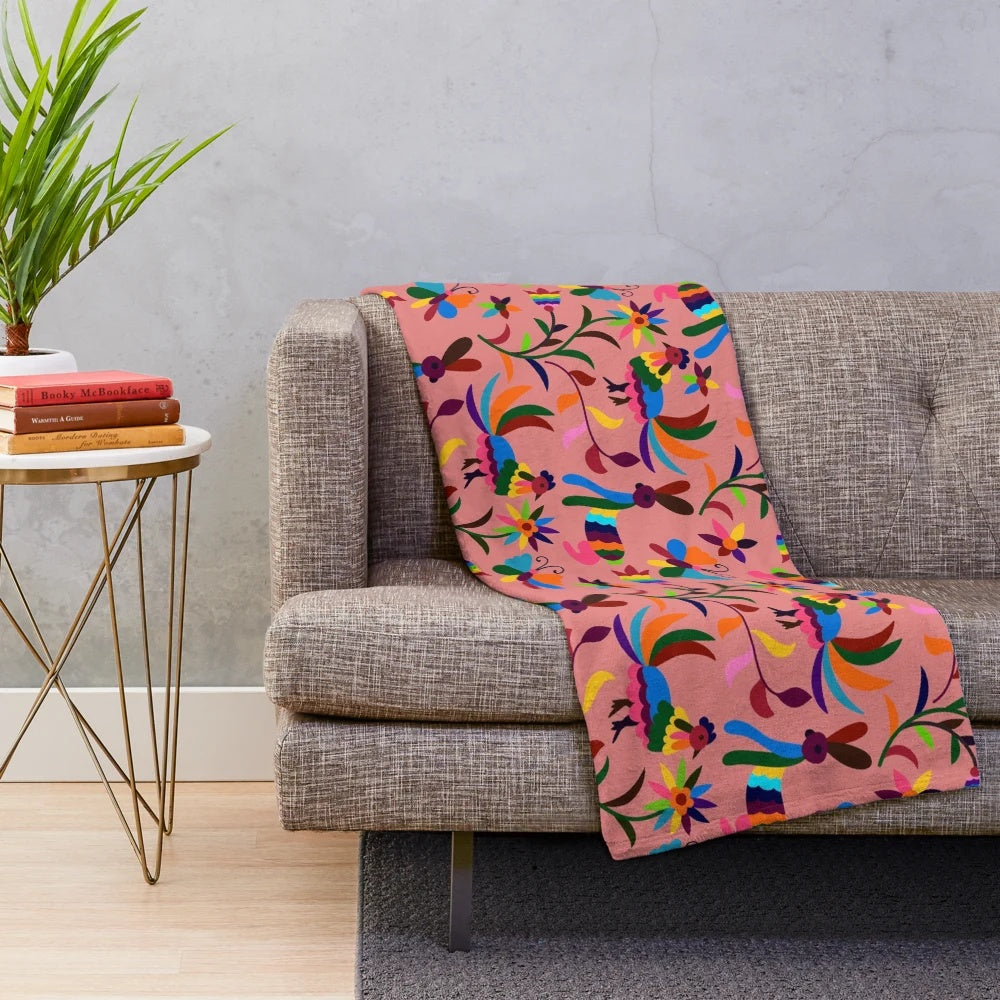 Pink plush blanket with colorful otomi pattern featuring cartoon animals