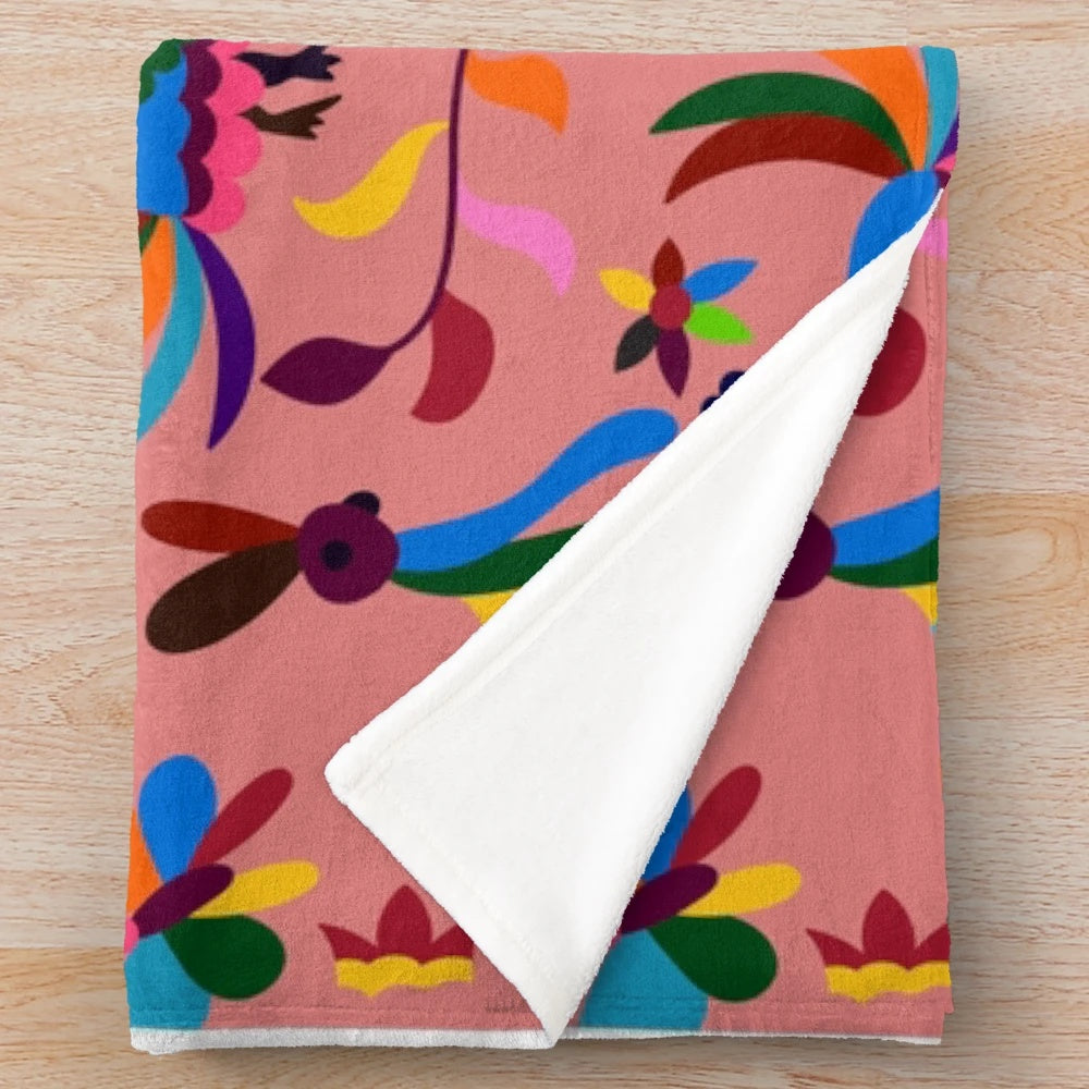 Pink plush blanket with colorful otomi pattern featuring cartoon animals
