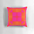 Vibrant pink and orange graphic pillow with squares and triangles