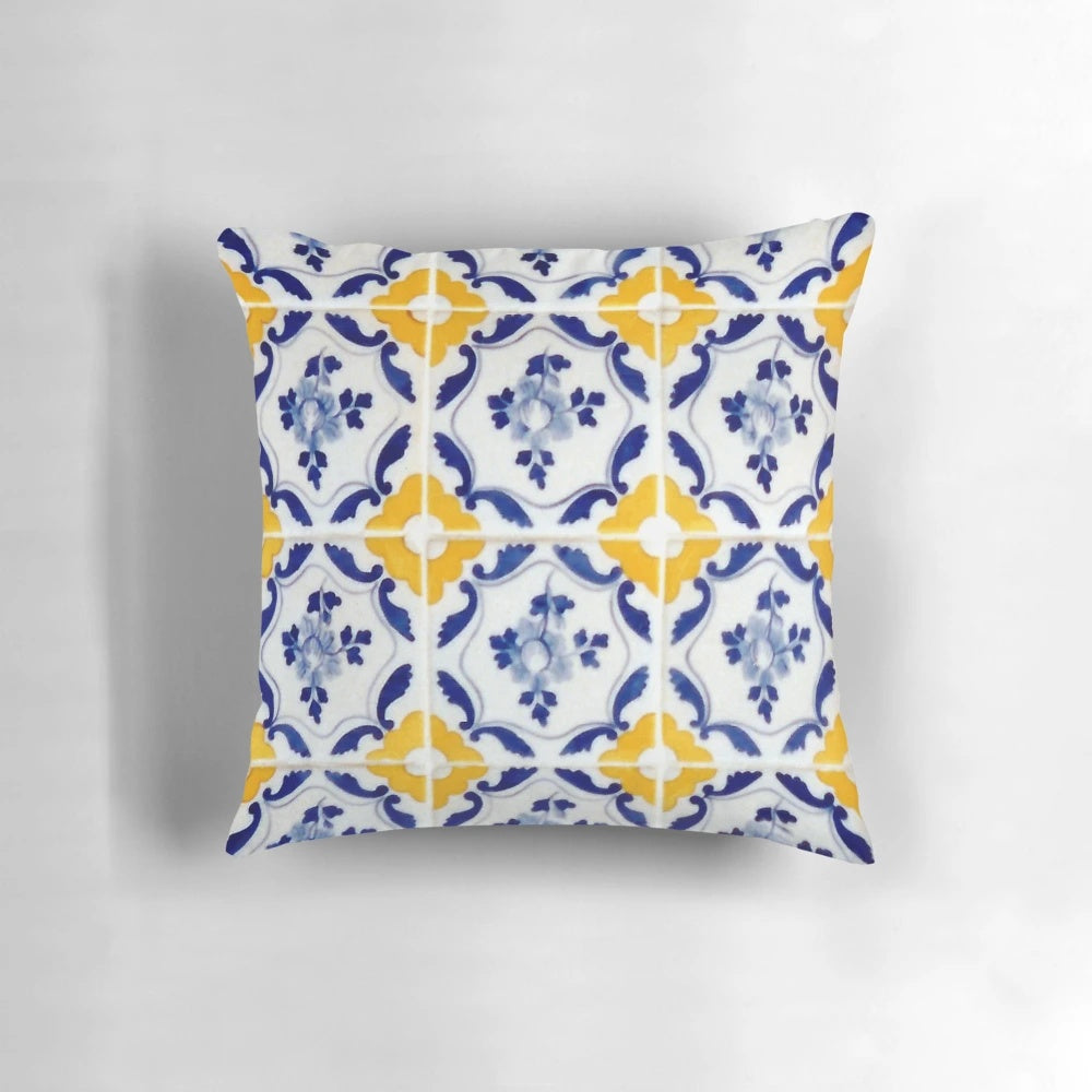 A pillow featuring a colorful pattern of blue and yellow Portuguese-inspired tiles.