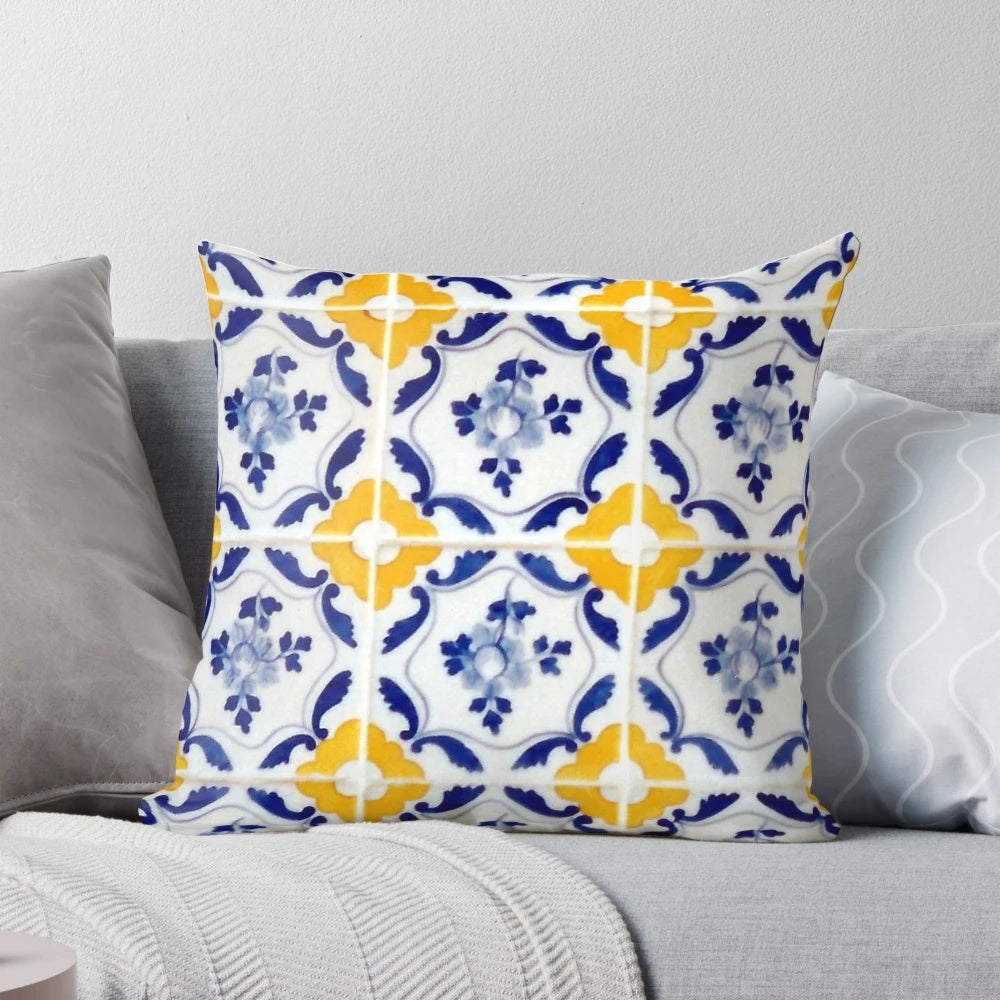 A pillow featuring a colorful pattern of blue and yellow Portuguese-inspired tiles.