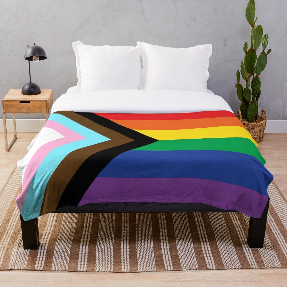 Plush blanket in the colors of the progress pride flag, representing LGBTQIA+ diversity and inclusion.
