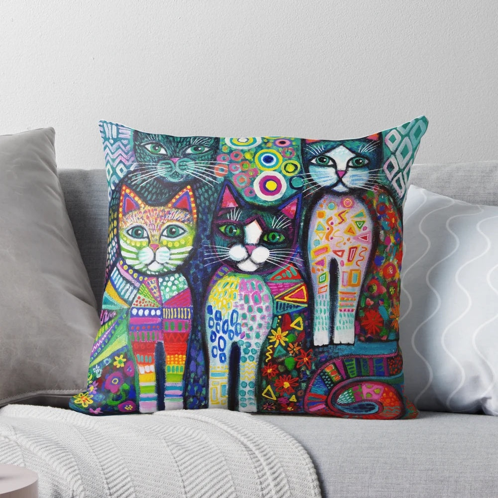 Colorful and whimsical decorative pillow featuring a vibrant pattern of quirky cats in a naive art style