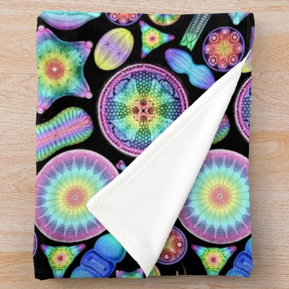 Vibrant rainbow diatoms pattern on a soft, plush blanket inspired by the scientific illustrations of Ernst Haeckel