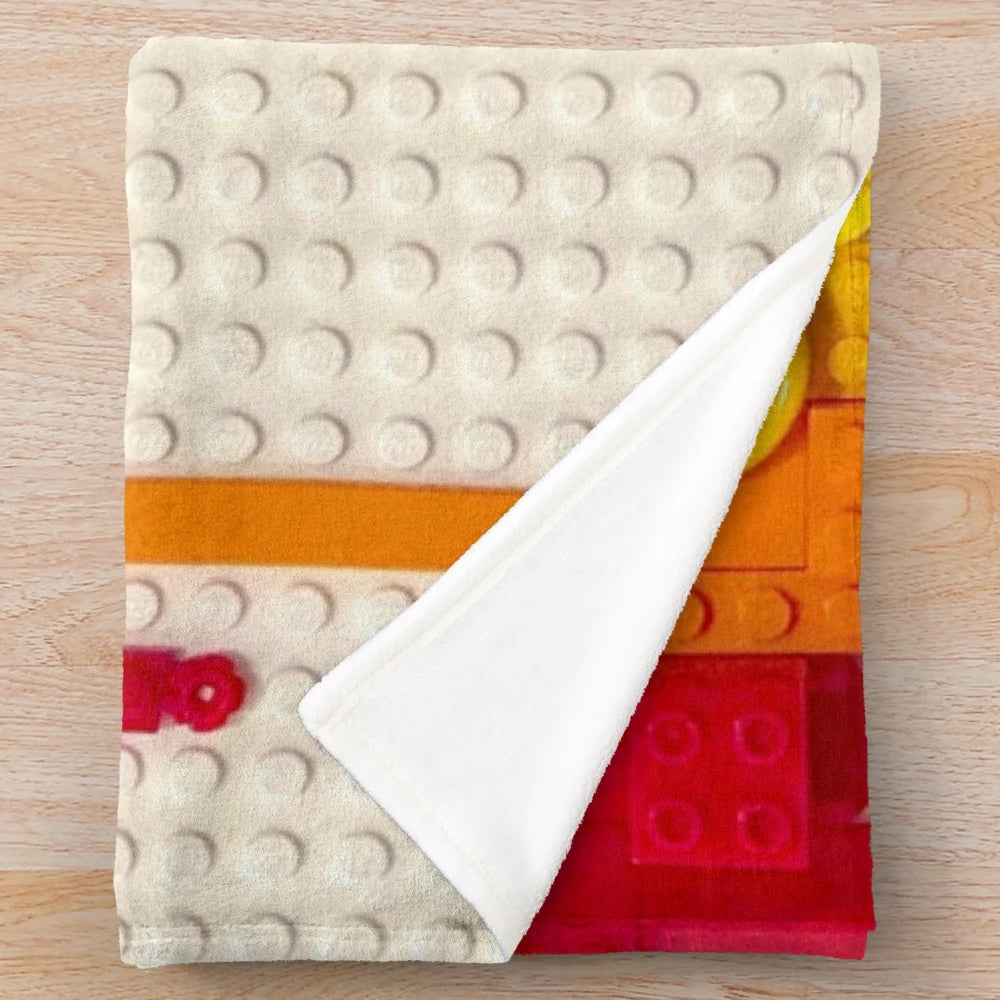 Colorful rainbow drip plush blanket with lego-inspired xray skeleton design