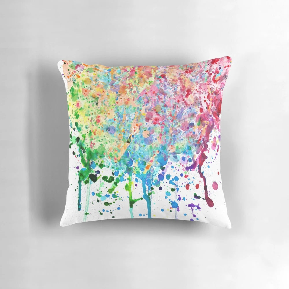 Colorful rainbow paint splatter and drip design on a decorative throw pillow